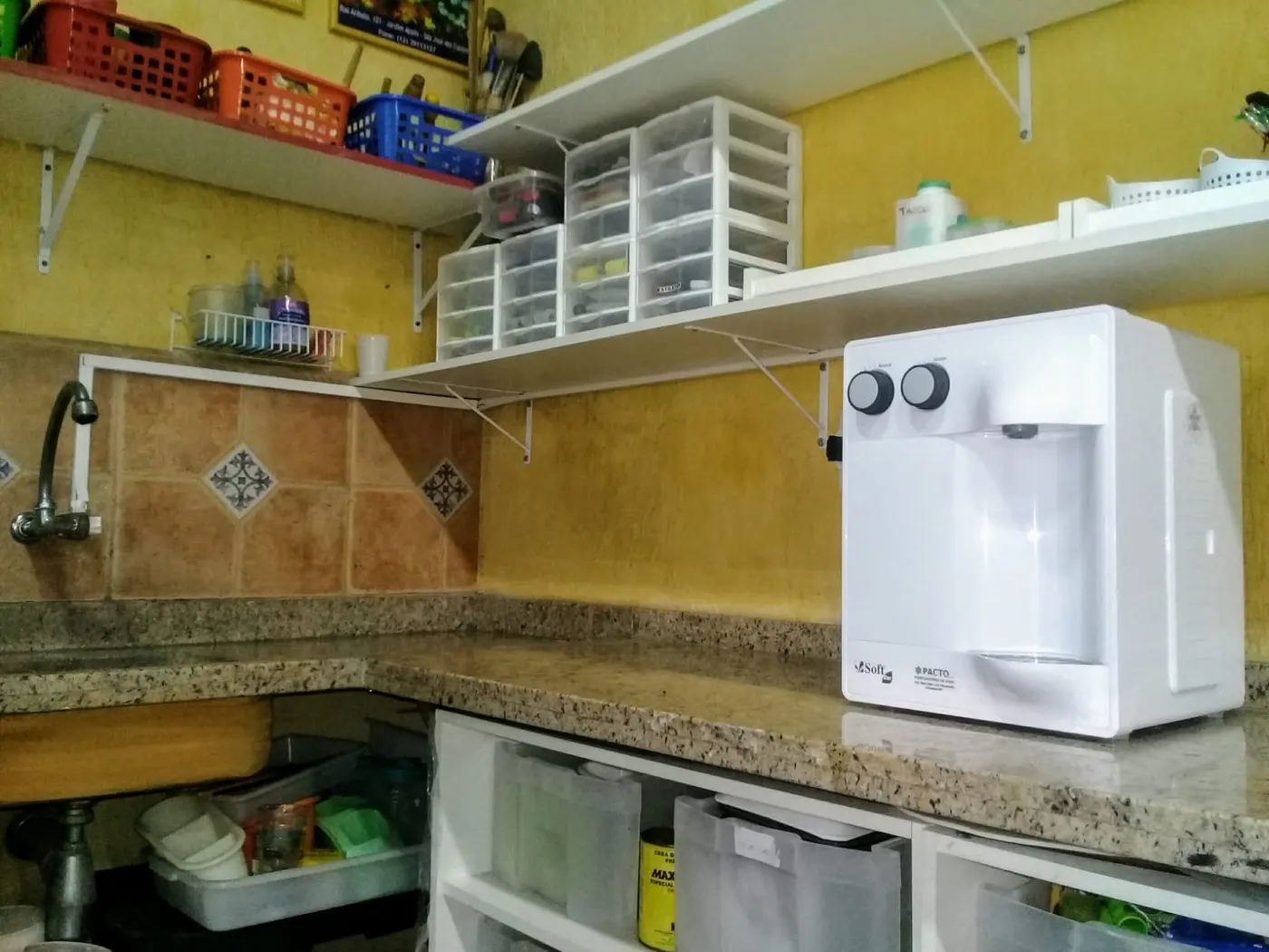 Purificador de água Soft branco apoiado em bancada de granito em cozinha residencial